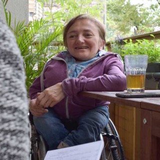 Rebecca Maskos sitzt mit einem Tee an ihrem Balkontisch