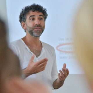 Chadi Bahouth gestikuliert während seines Vortrags vor Nachwuchsjournalisten