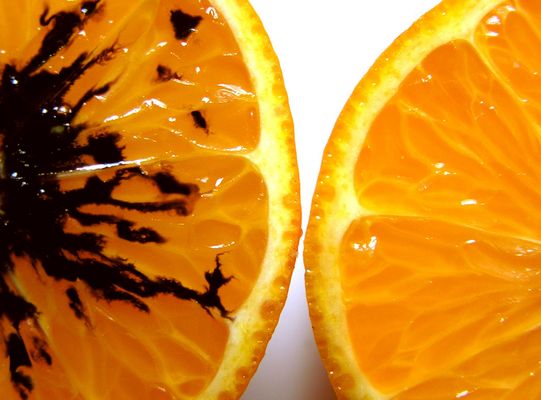 Es sind zwei Orangenhälften zu sehen, eine gute und eine schlechte.
