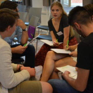 Eine kreative Runde auf der Jugenkonferenz. Vier Personen sitzen und bilden einen Kreis.