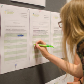 Eine Teilnehmerin sucht sich ihre Workshops für das Wochenende aus.