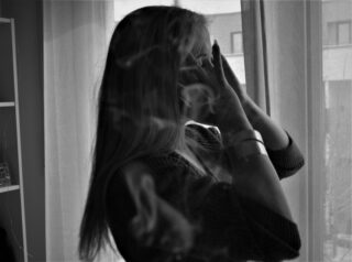 eine junge Frau steht vor einem Fenster