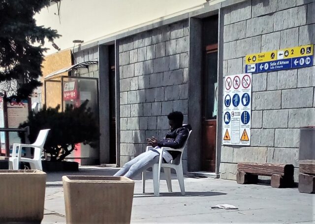 Ein Junge sitzt auf einem Stuhl und schaut in sein Smartphone