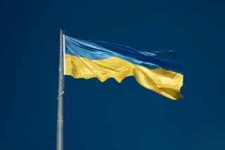 Eine ukrainische Flagge weht am tiefblauen Himmel.