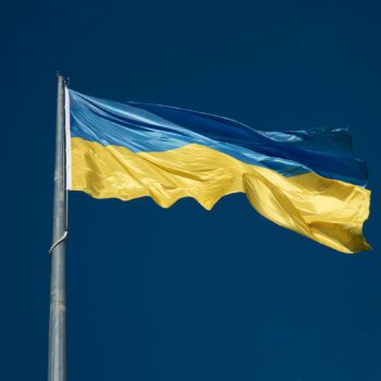 Eine ukrainische Flagge weht am tiefblauen Himmel.