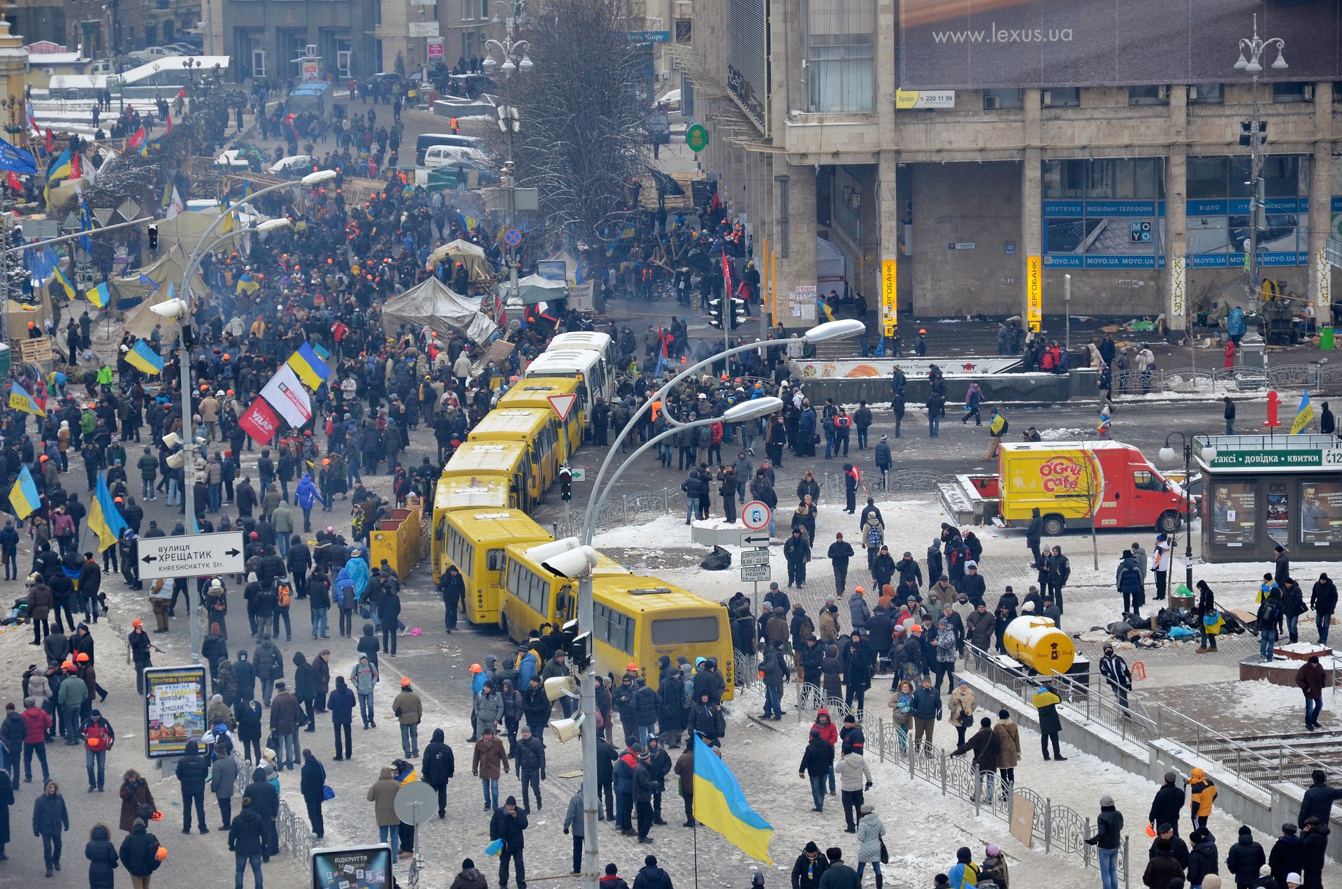 Menschen demonstrieren mit ukrainischen Flaggen. Es liegt Schnee. Die Stadt ist voll.