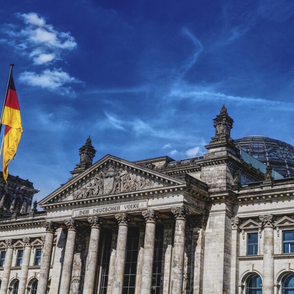 Das Reichstagsgebäude steht im Mittelpunkt. Links ist eine deutsche Flagge erkennbar.