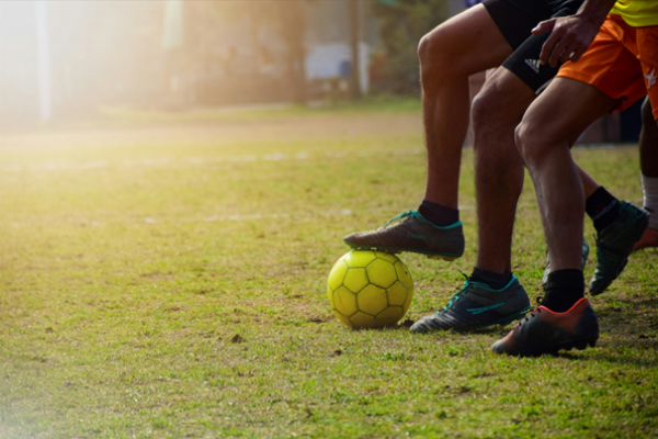 Beine kicken einen Fußball.