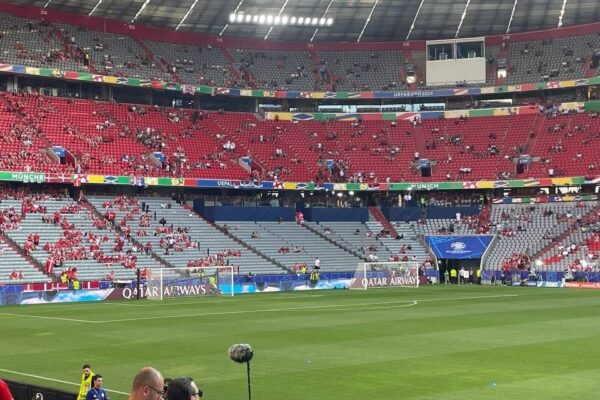 Ein Fußball-Stadion ist halbgefüllt. Auf den Werbebannern ist Qatar Airways Werbung zu sehen. 